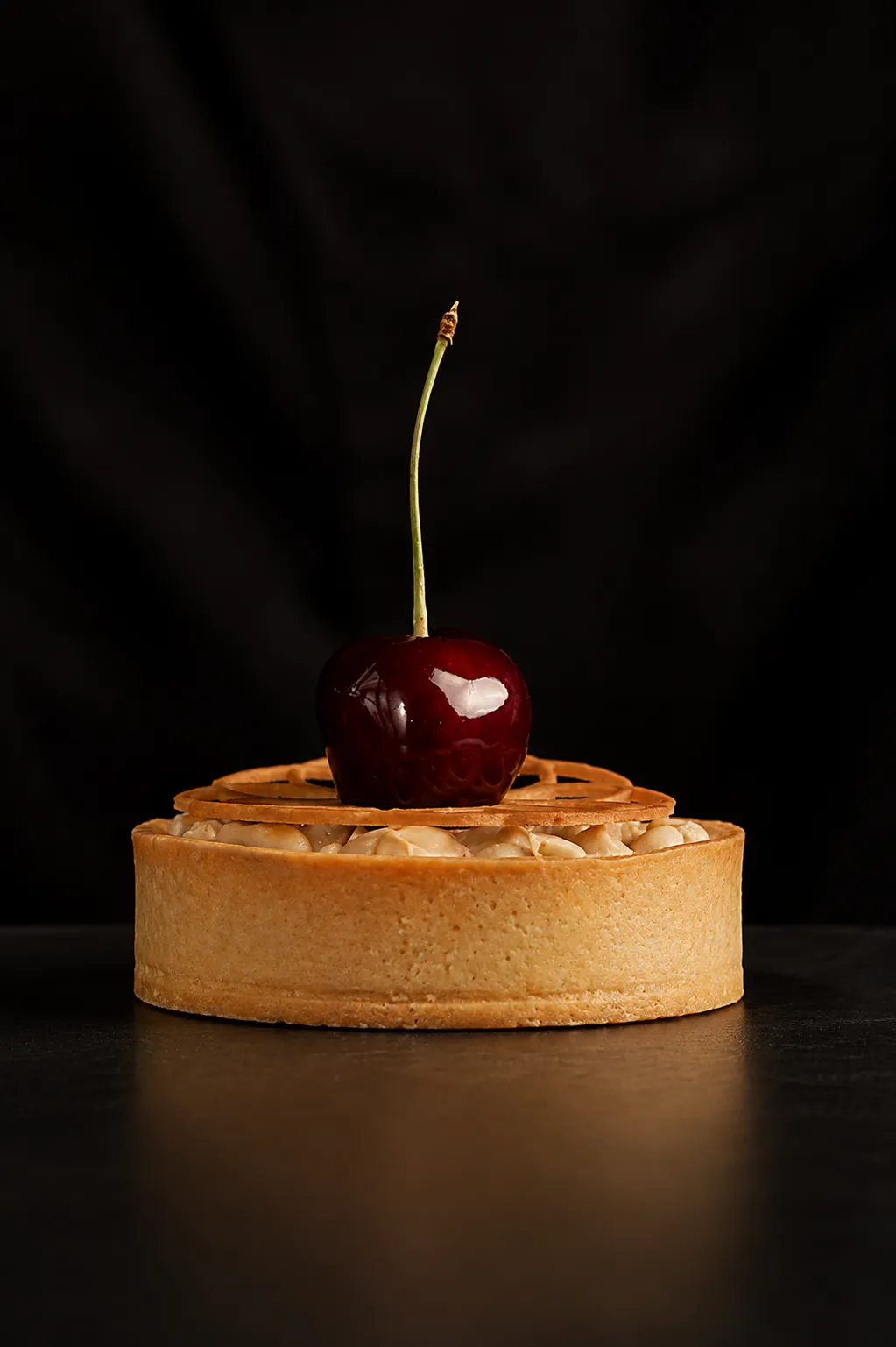 Frangipane tart topped with a single glazed cherry